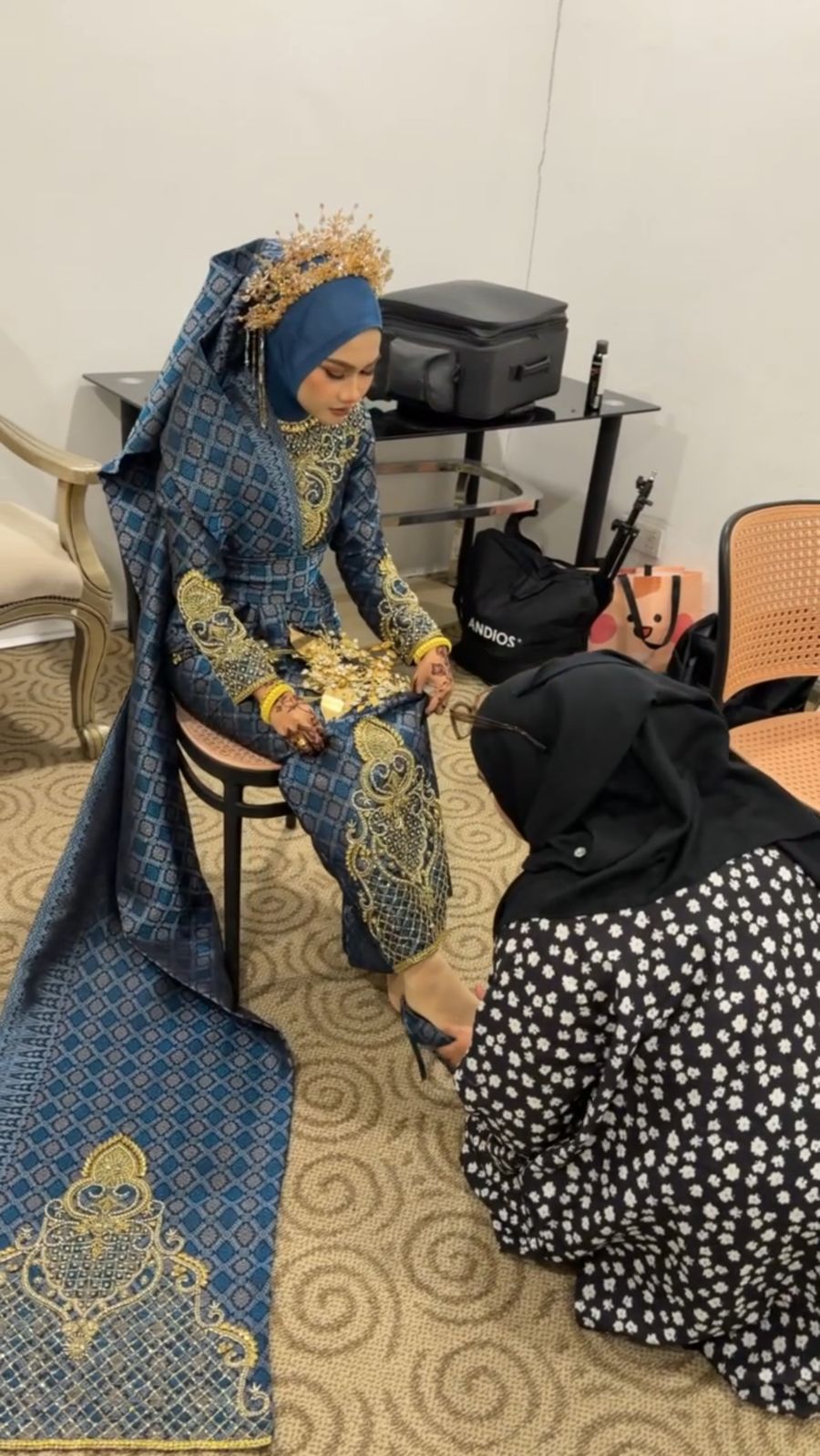 Alya fixing the bride's songket train