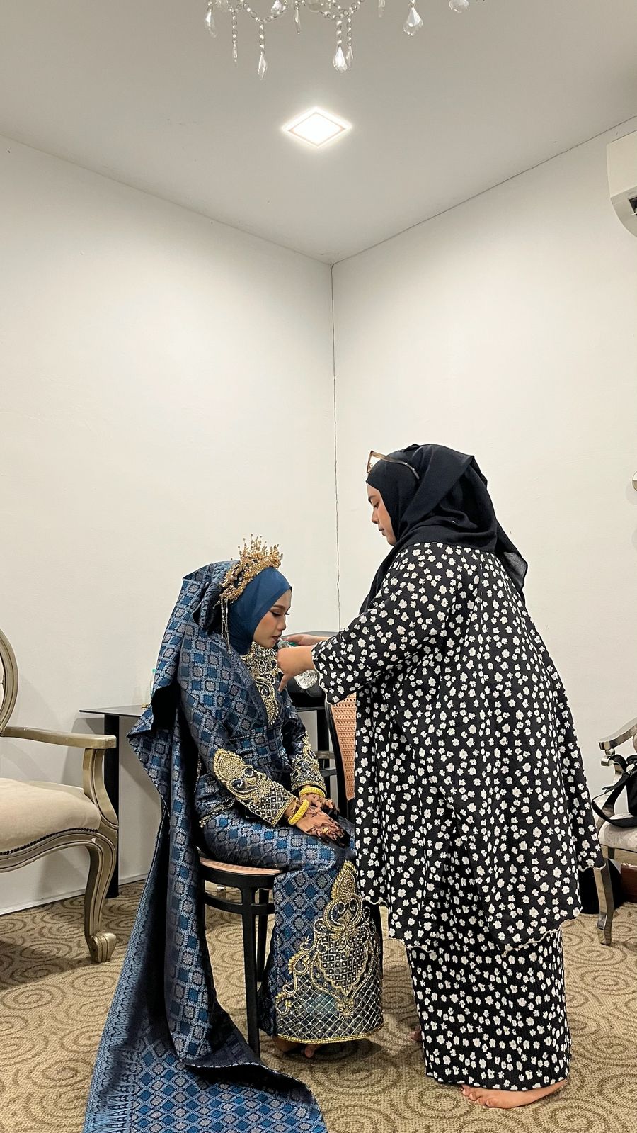 Alya adjusting the bride's veil before the majlis