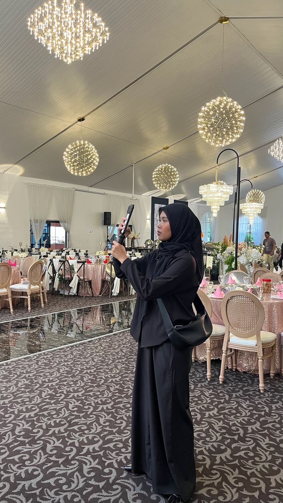 Fitrah filming a wedding reception on her phone